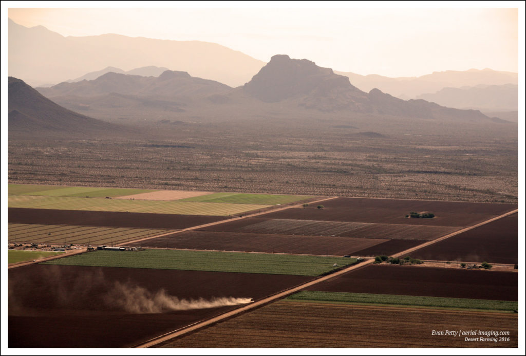 An Aerial View of A Farmer With A Dust Cloud